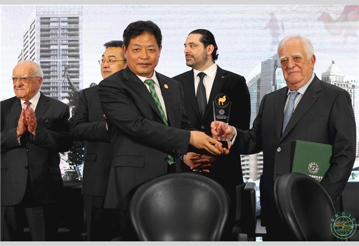 7--Mr. Lu presents the emblem to Mr. Adnan Kassar